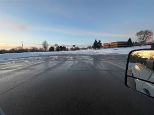 Heavy equipment removing snow from a commercial facility driveway.